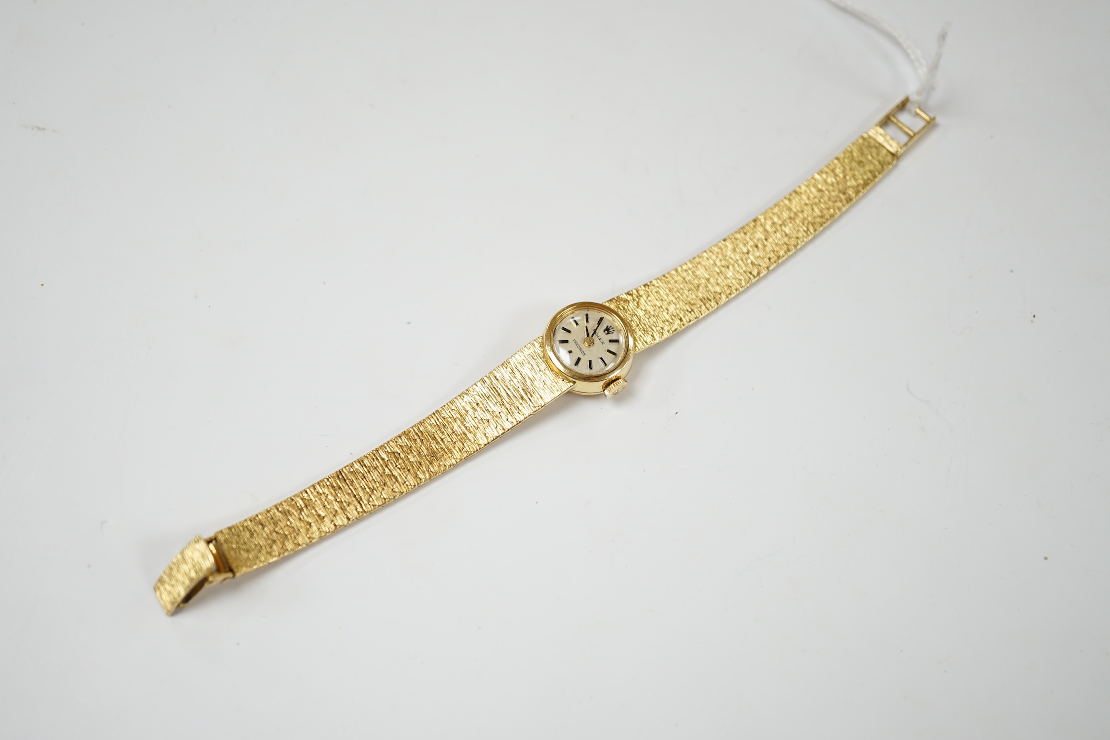 A lady's textured 750 yellow metal Rolex manual wind wrist watch, on integral bracelet, no box or papers, case diameter 15mm